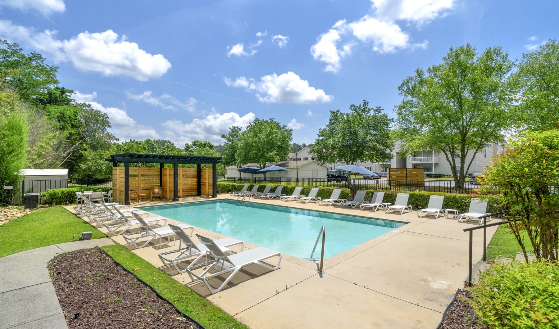 pool with ample seating and lush greenery surrounding it