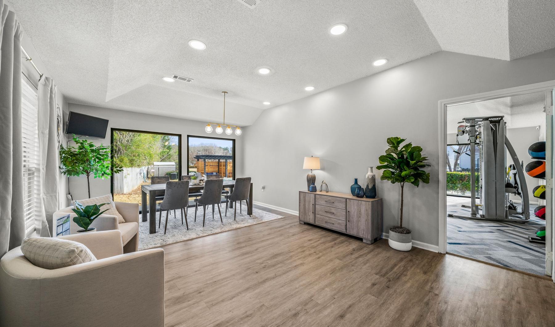 Cutting-edge amenities at your fingertips a clubhouse room with a wood floor, chairs and tables