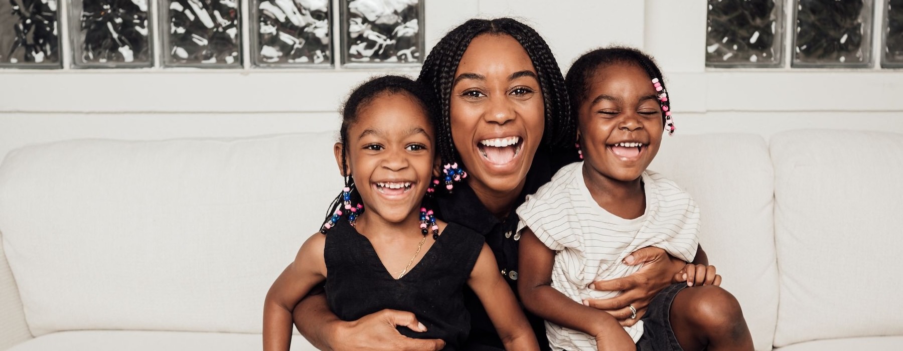 a woman sitting on a couch with two kids