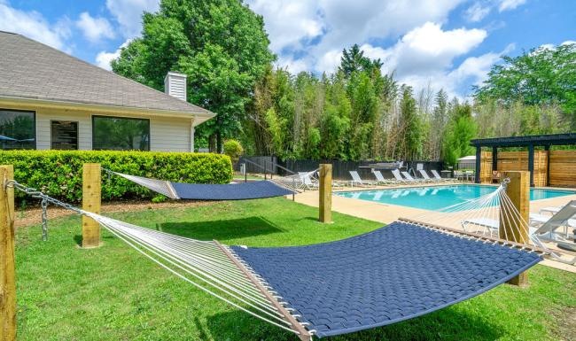 Cutting-edge amenities at your fingertips a pool area with grass and hammocks