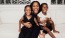 a woman sitting on a couch with two kids